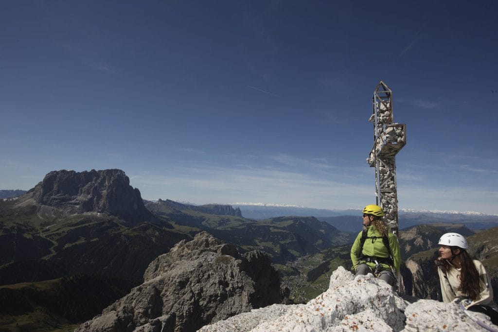 Am Ziel: Das Kreuz markiert Gipfel und Ziel der hochalpinen Klettertour in Gröden.